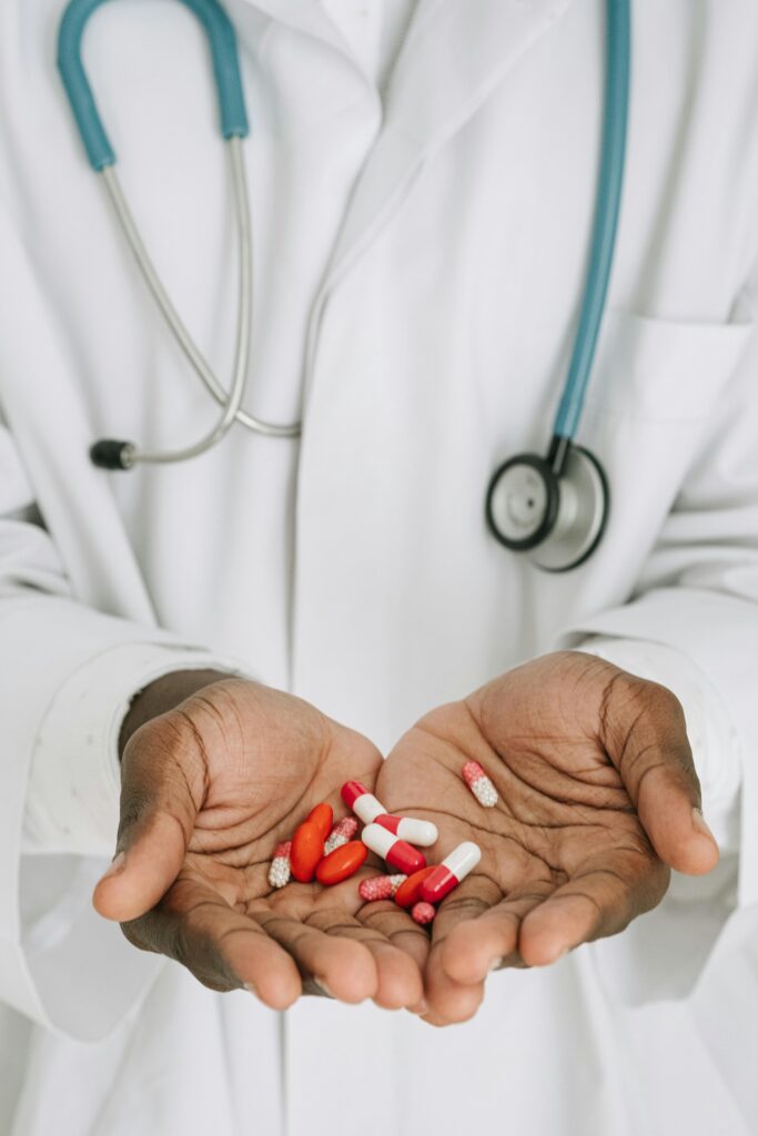 A doctor in a medical gown holding capsules, illustrating healthcare concepts.